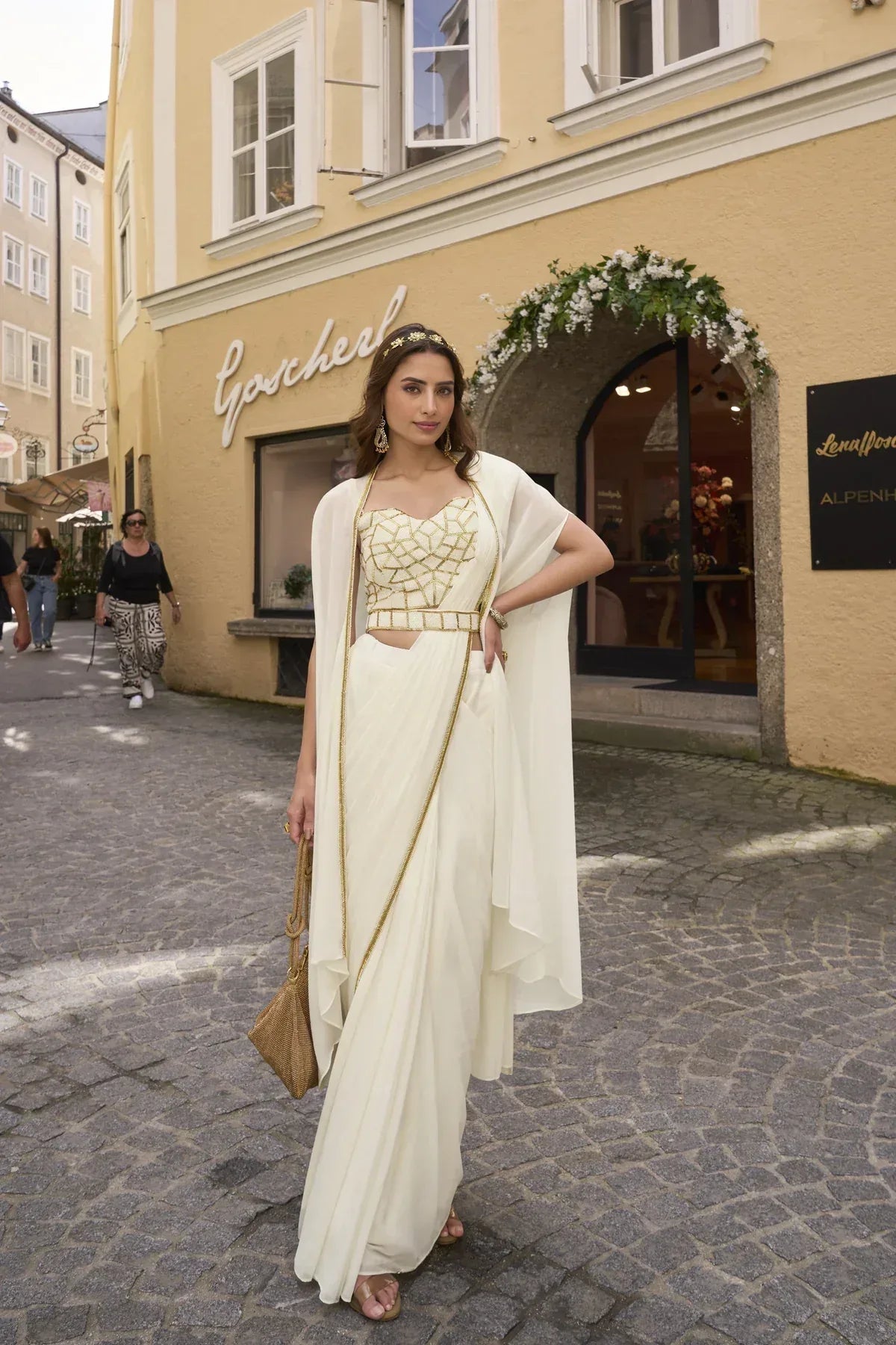 Ivory drape saree with a handworked gold blouse and an attached cape