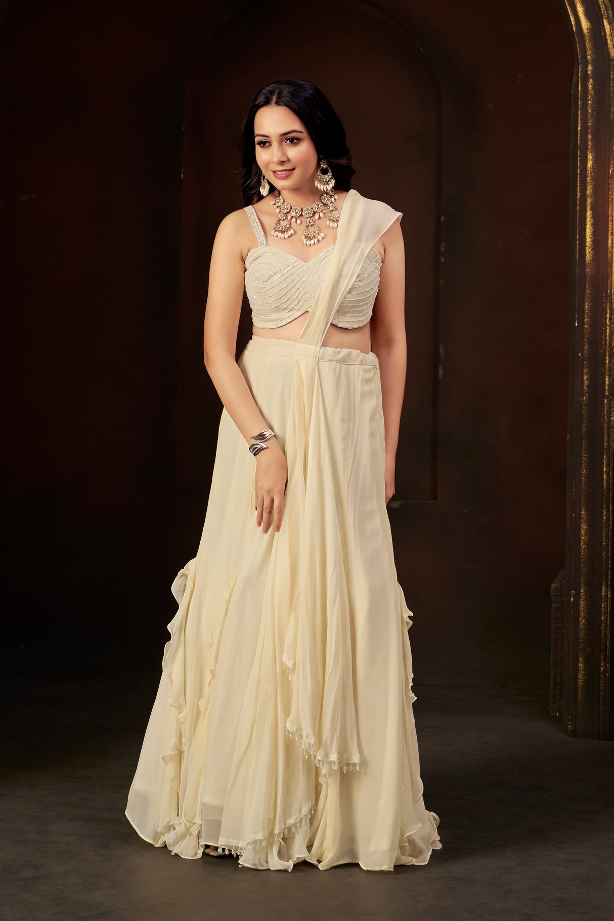 Ivory Ruffle Layered Georgette Lehenga Set with Embroidered Sheer Cape & Draped Corset Blouse – Minimalist Luxe Couture