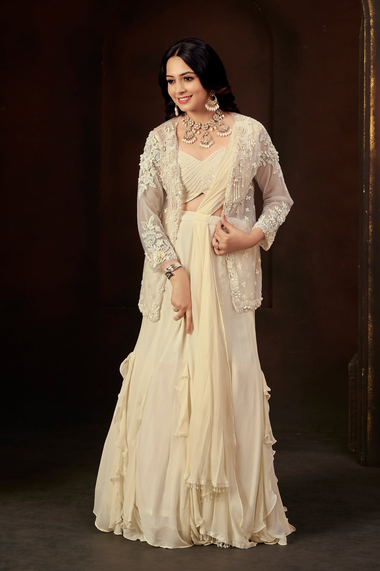 Ivory Ruffle Layered Georgette Lehenga Set with Embroidered Sheer Cape & Draped Corset Blouse – Minimalist Luxe Couture