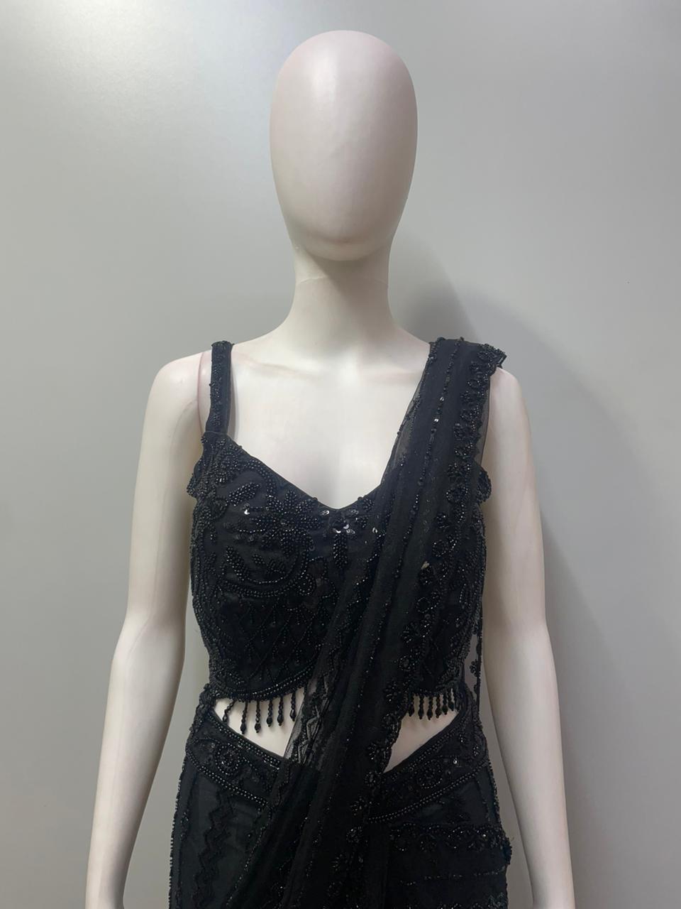 Close view of the crystal beadwork and hanging bead accents on a black blouse