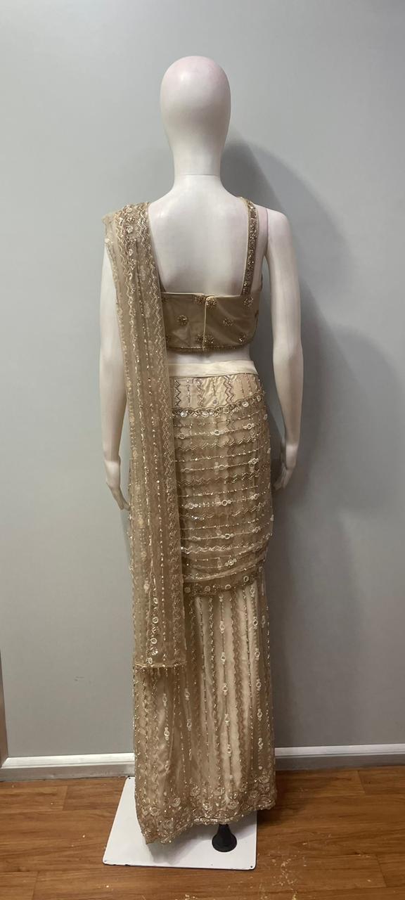 Side view showing the ruched hip and vertical detailing on a taupe draped skirt