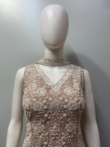 Close view of the pearl beadwork and floral motifs on a dusty rose top