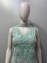 Close view of the silver beadwork and floral motifs on an aqua mint top