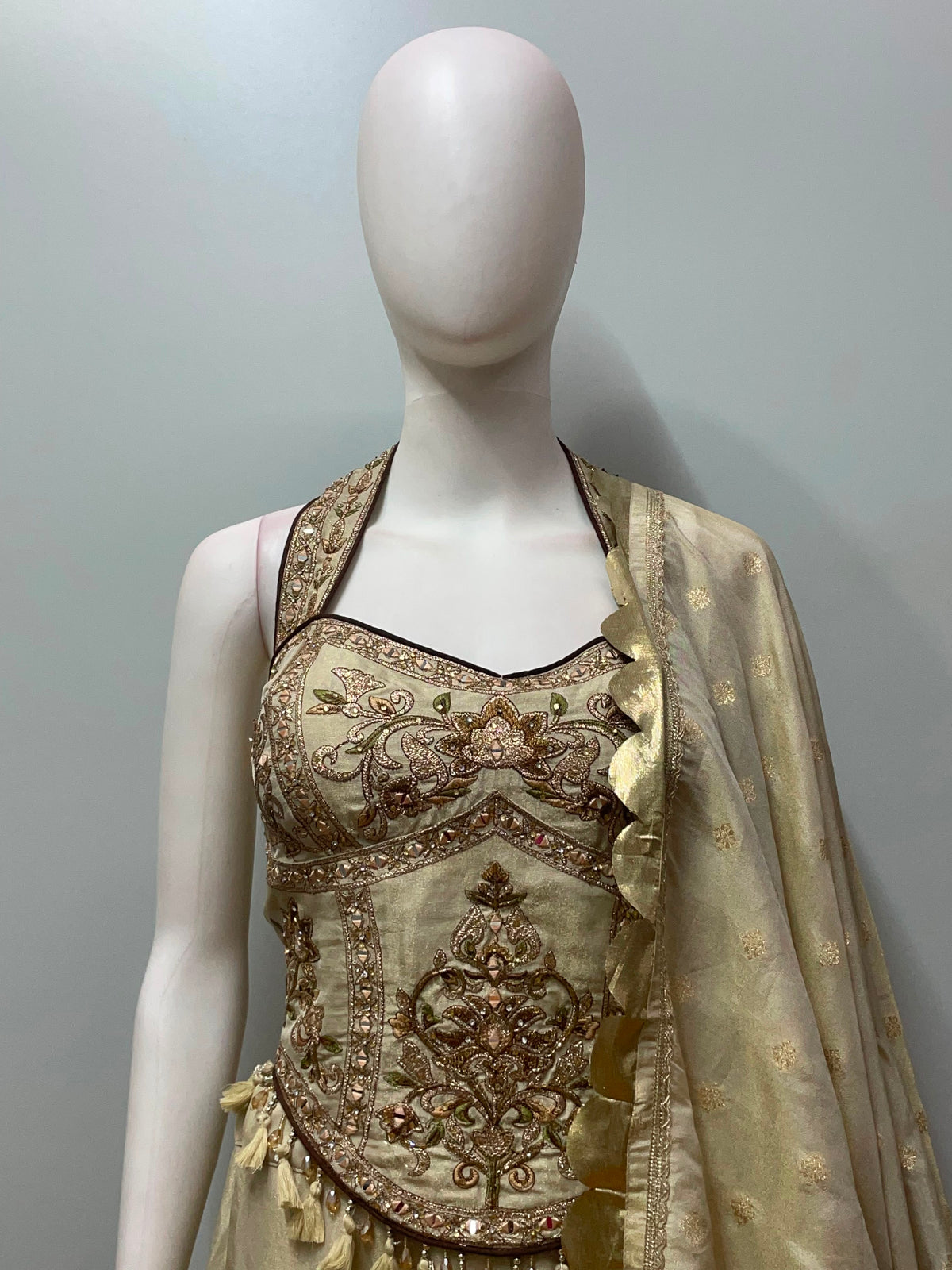 Full-length view of an ivory gold corset embroidered lehenga set