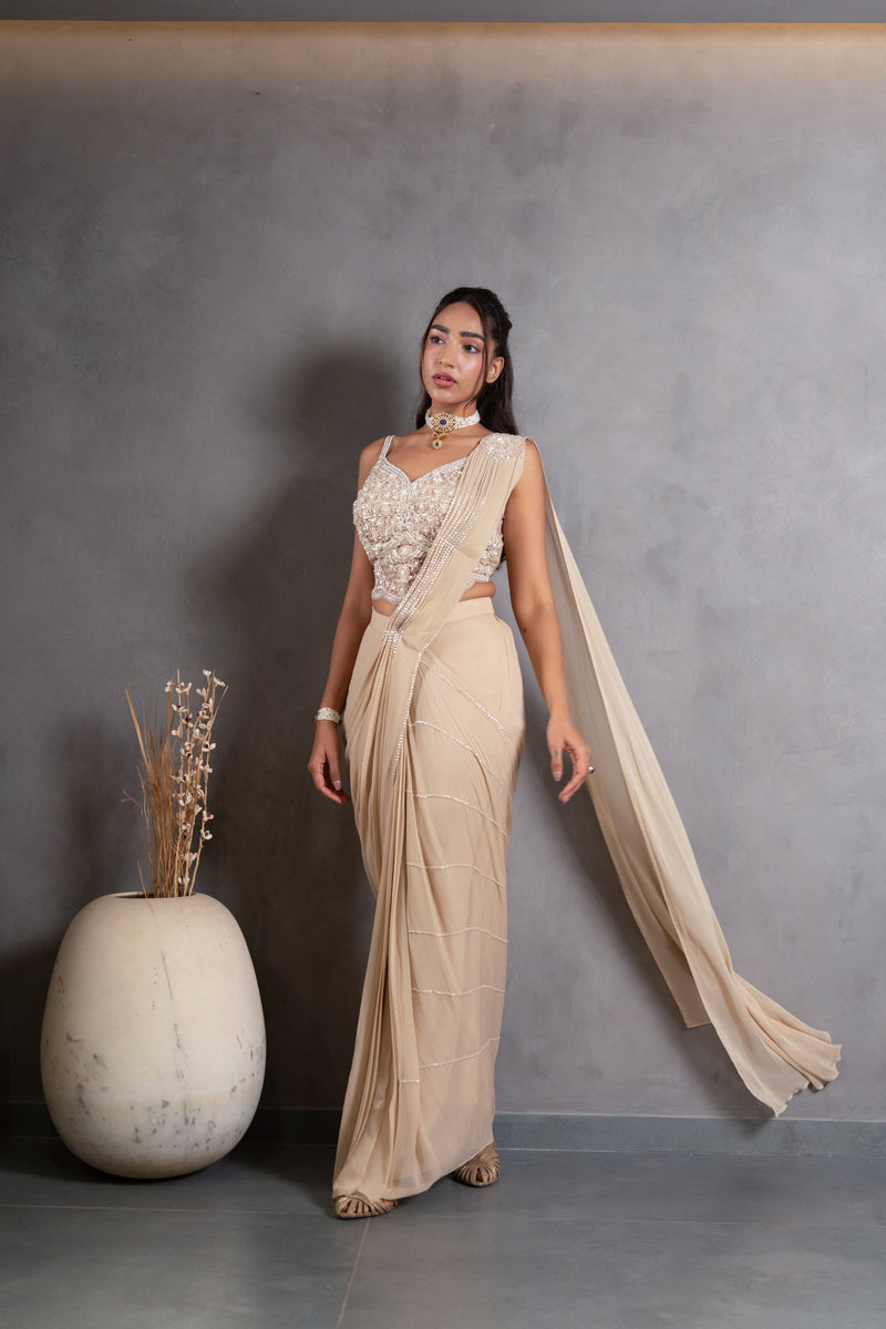 Close view of the pearl detailing on a champagne draped saree