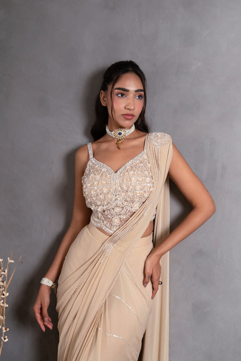 Full-length view of a champagne pearl draped saree on the model