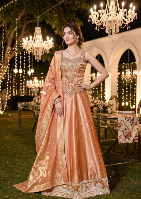 Peach corset lehenga with champagne gold jewel work and an ornate paisley hem border