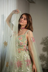 Sage floral net lehenga photographed against a plain backdrop