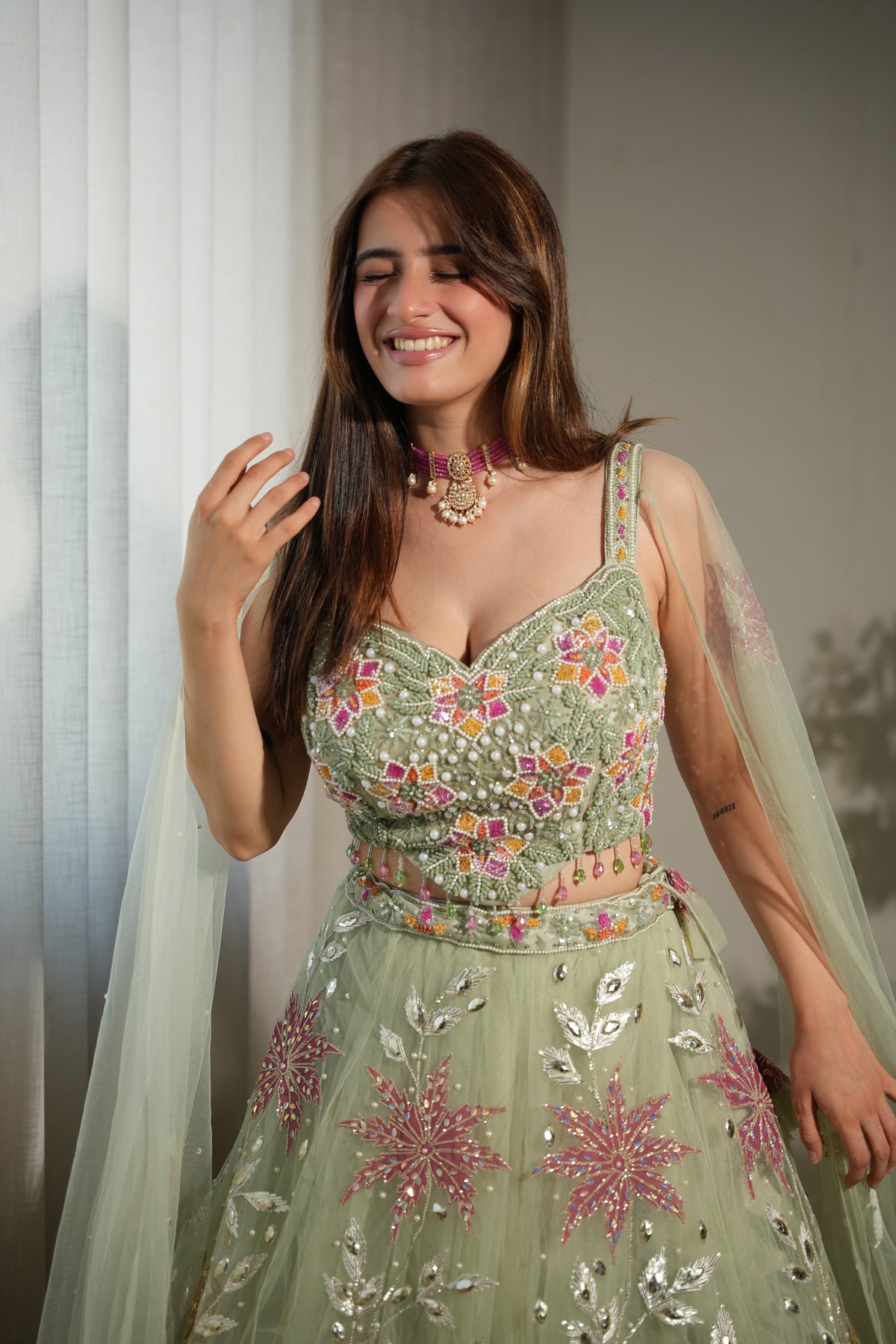 Full-length view of a sage floral net lehenga ensemble on the model