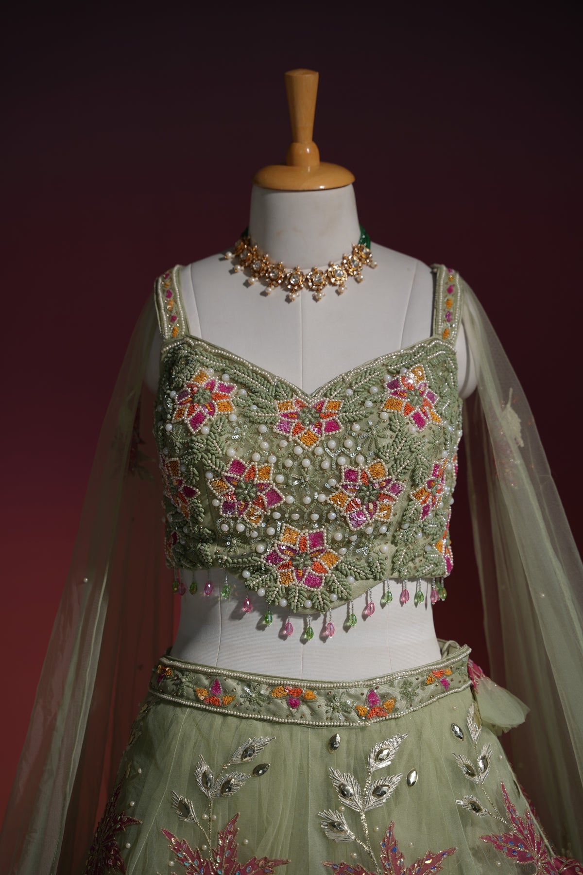 Detail of the dupatta edging on a sage floral net lehenga set