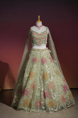 Hem detail on the skirt of a sage green floral net lehenga set