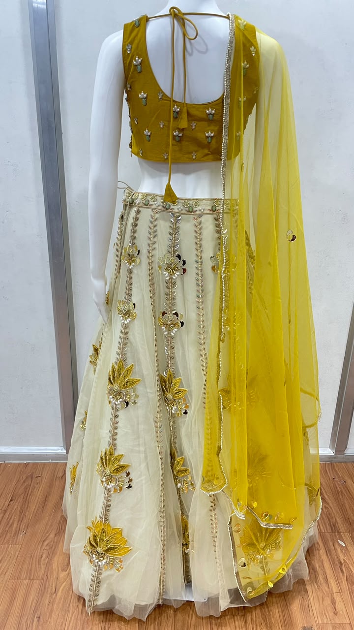 Mustard floral lehenga choli photographed against a plain backdrop