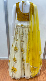 Mustard floral lehenga choli photographed against a plain backdrop