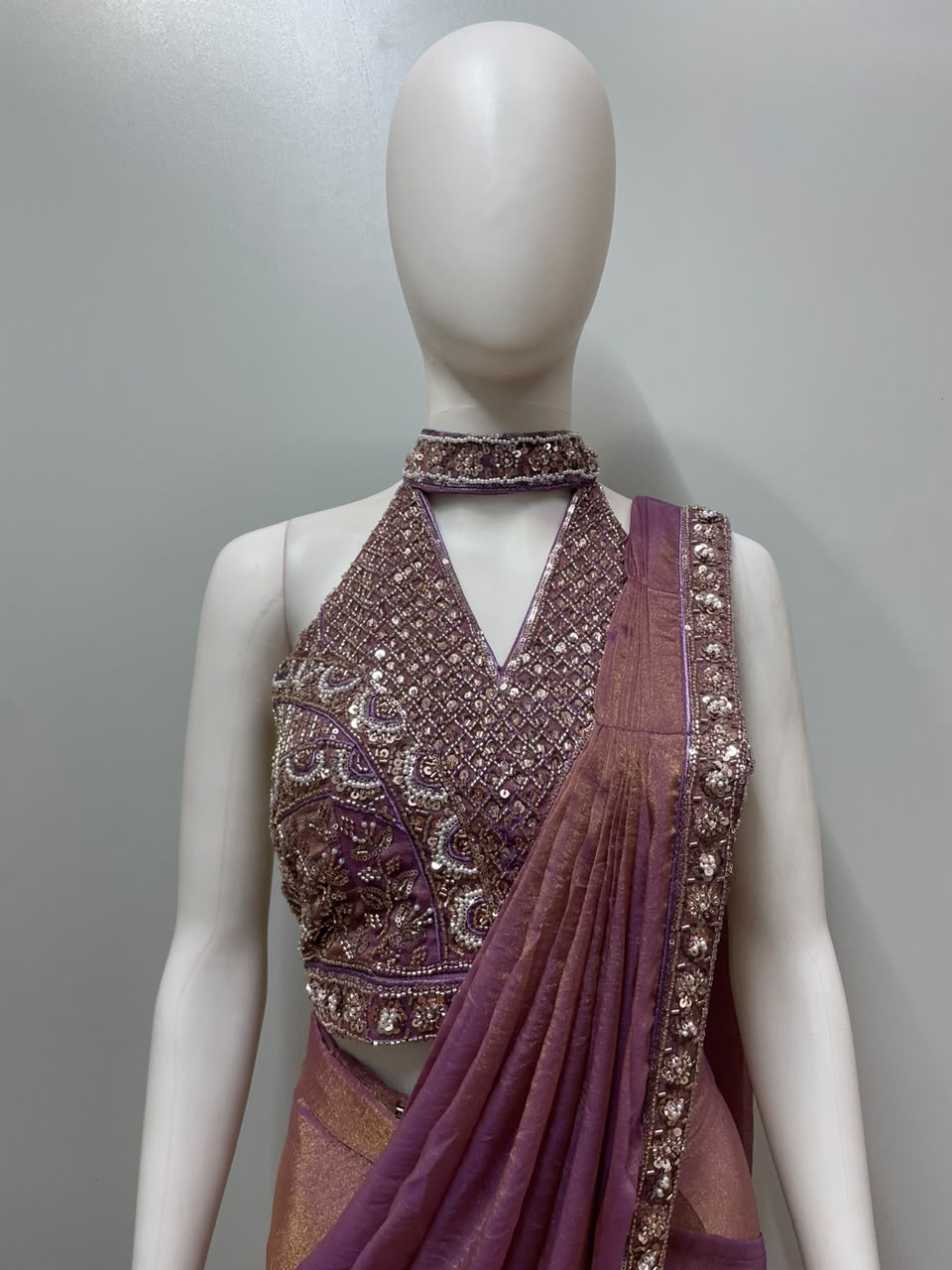 Full-length view of a mauve bronze embellished draped saree set