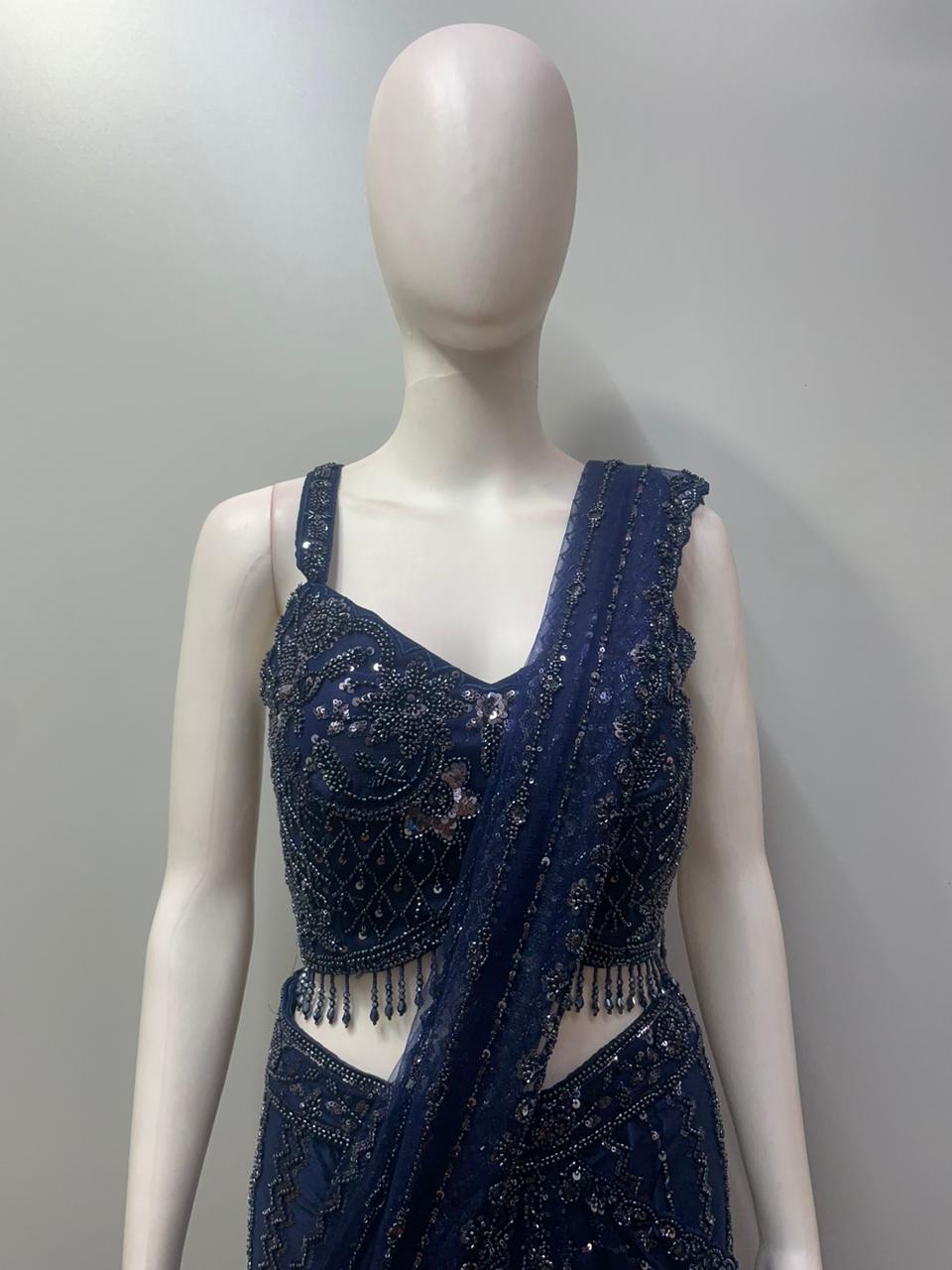 Close view of the crystal beadwork and hanging accents on a midnight blue blouse