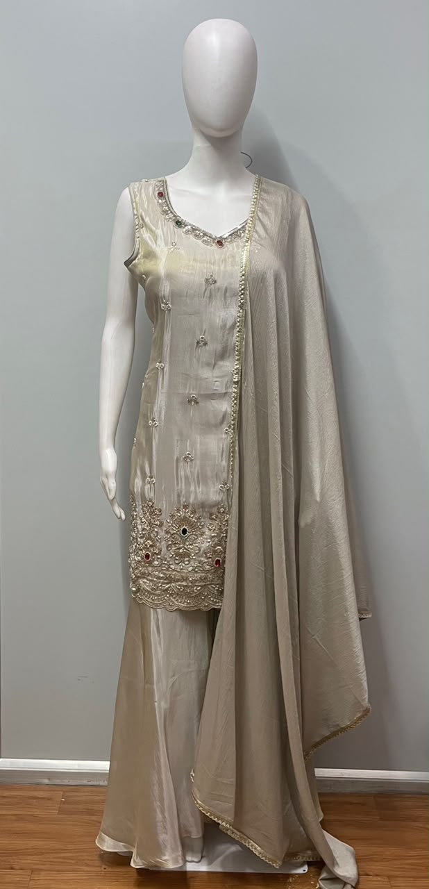 Close view of the gold work on an ivory sharara kurta and dupatta