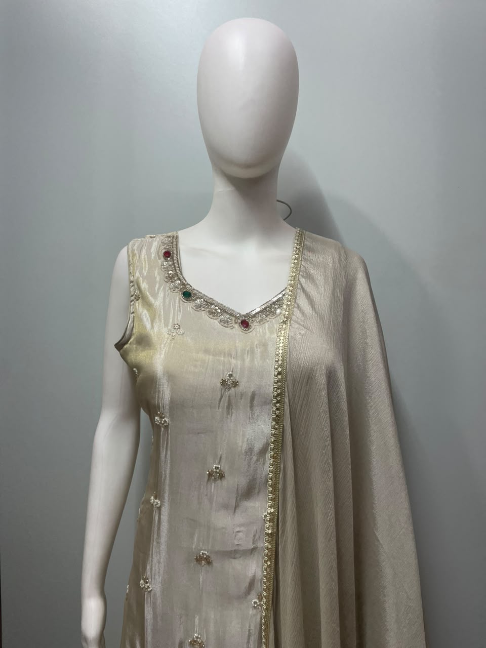 Full-length view of an ivory and gold sharara suit set on the model