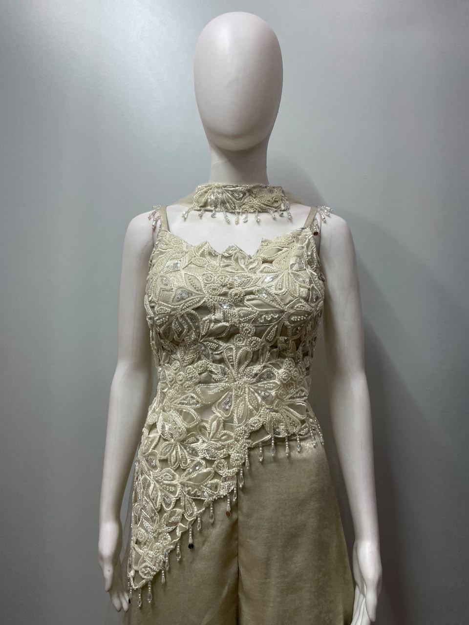 Close view of the pearl work on an ivory cape and palazzo set