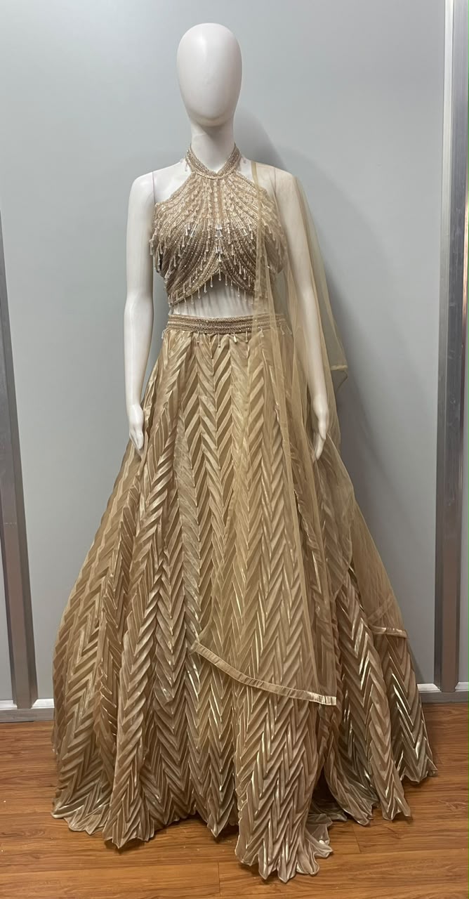 Champagne shimmer lehenga photographed against a plain backdrop