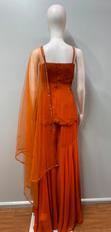 Tangerine peplum palazzo set photographed against a plain backdrop