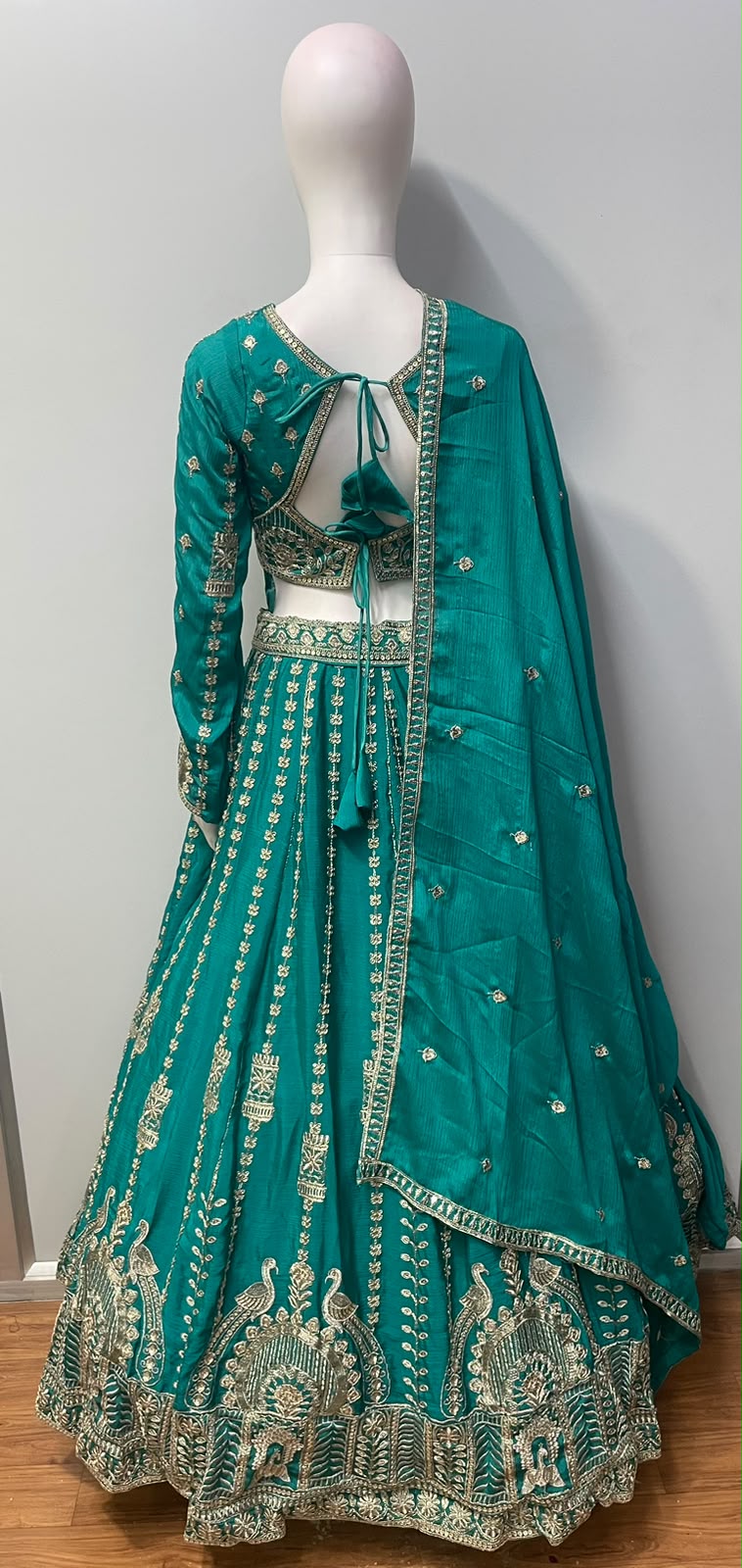 Flared peacock teal lehenga skirt with peacock motifs along the antique gold hem