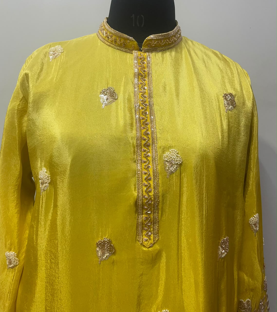 Gold peacock and floral border detail on a chartreuse yellow kurta