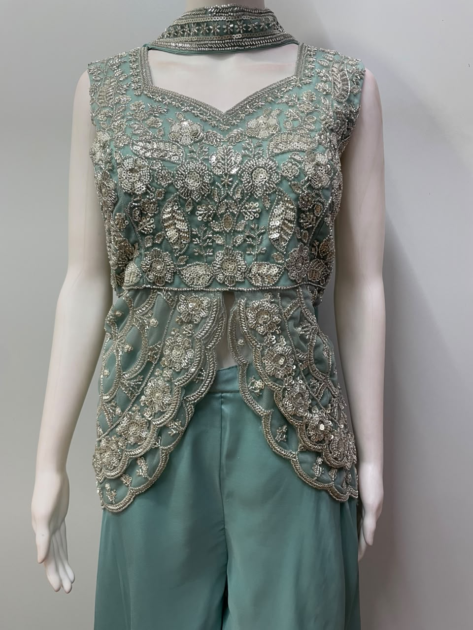 Sheer scalloped peplum layer over the dusty teal waist