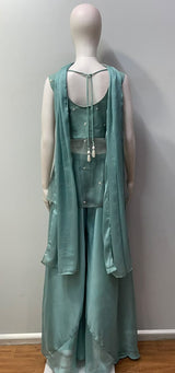 Wide-leg dusty teal trousers worn beneath the peplum top