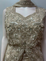 Scalloped hem of the split-front peplum top in champagne gold