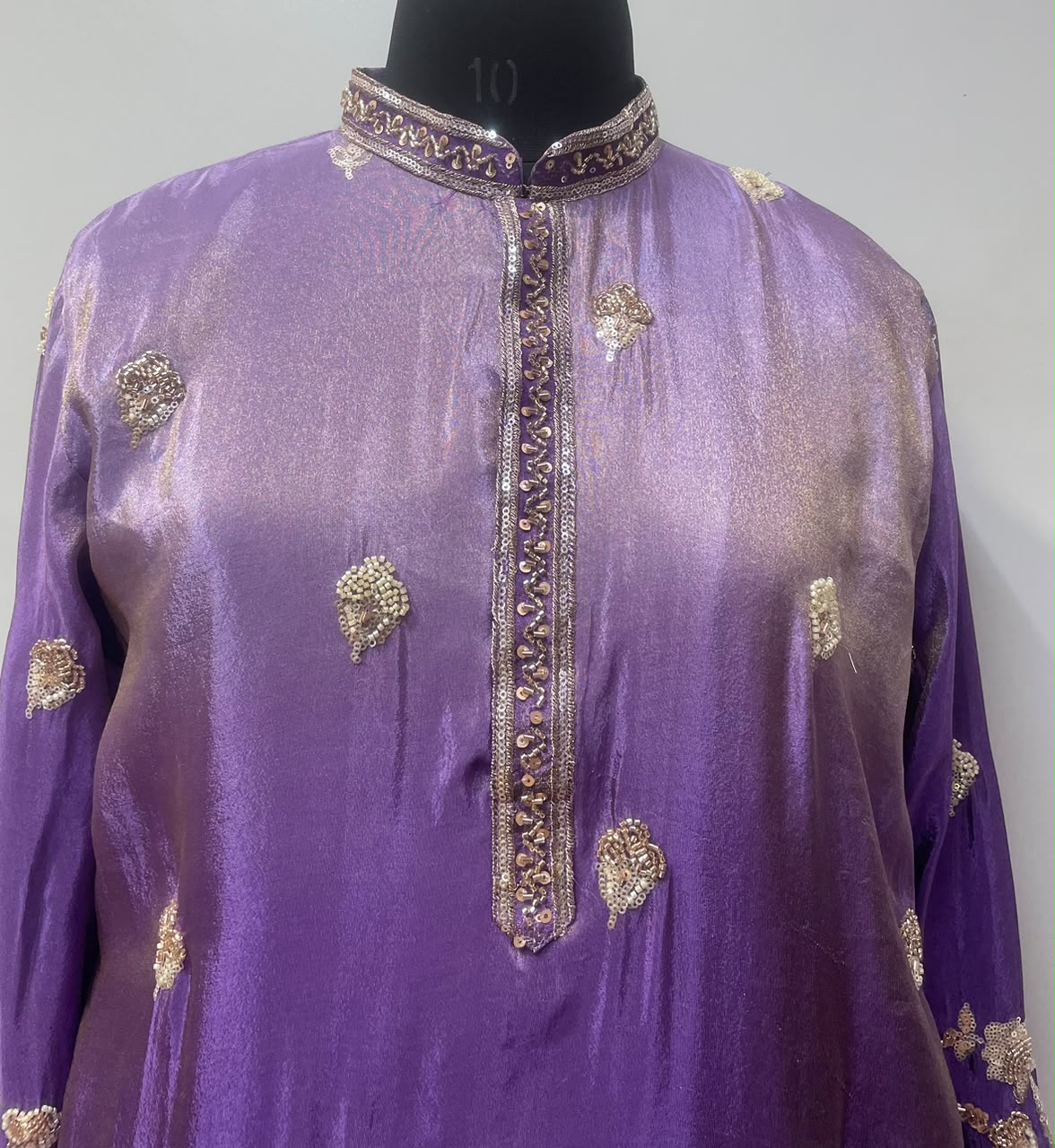 Gold peacock and floral border detail on a royal purple men's kurta