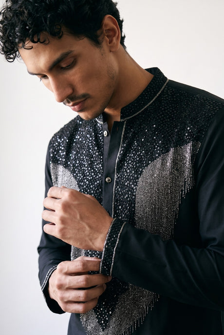 Silver fringe and thread detailing across the chest of the black men's kurta
