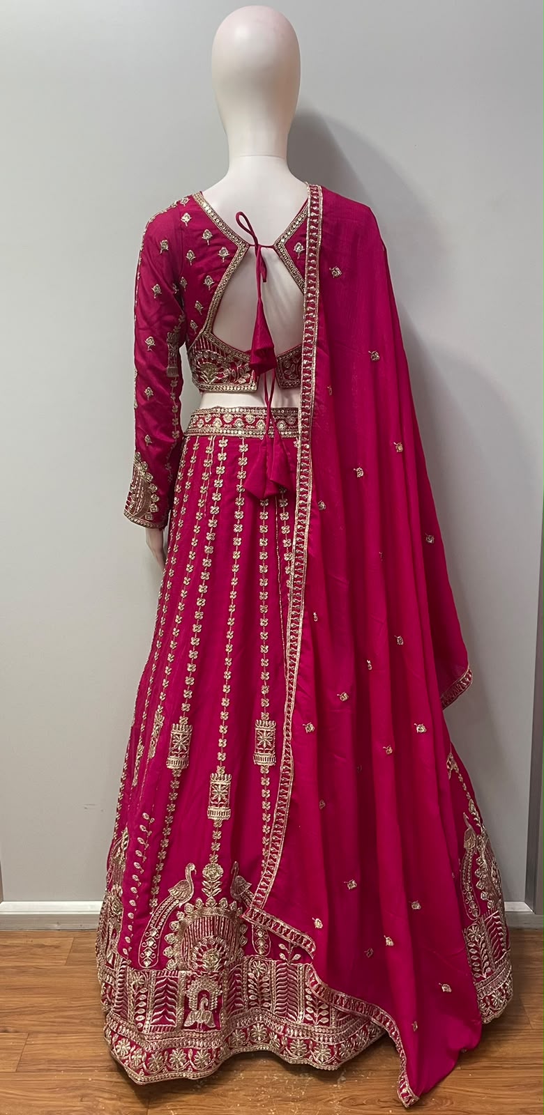 Flared fuchsia lehenga skirt with vertical floral trails and an antique gold hem border