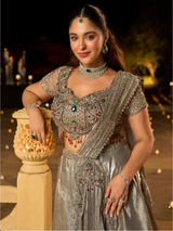 Cropped silver blouse worn with the floor-length draped lehenga