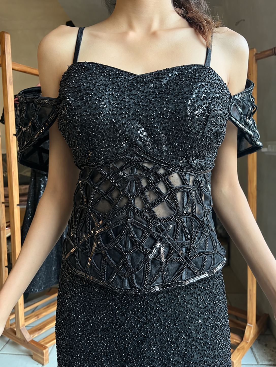 Off-shoulder detail on the sheer corset top of a jet black sequin skirt set