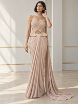 Blush champagne draped saree set with a pearl-detailed peplum blouse and a trailing drape