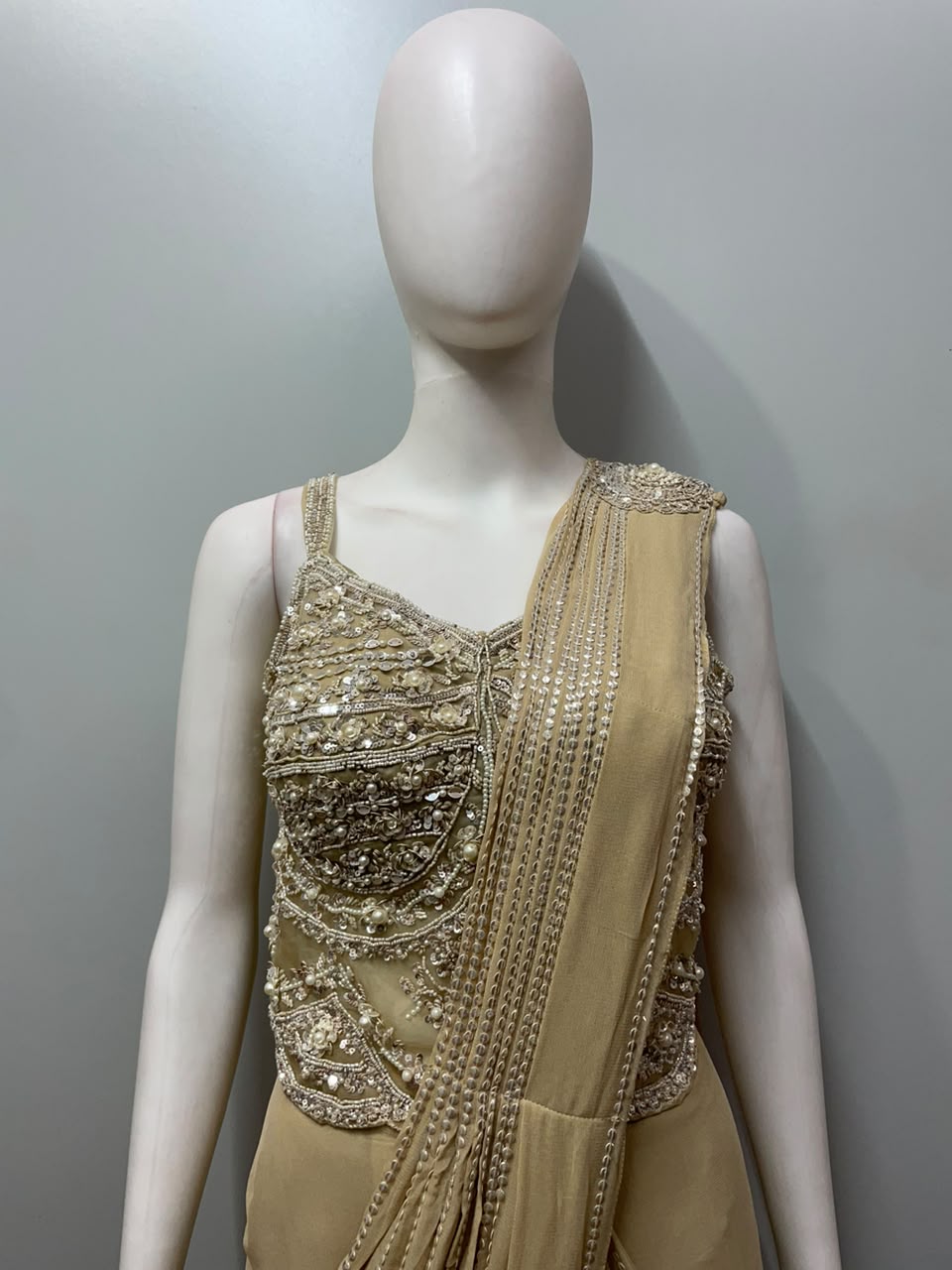 Champagne pearl draped saree photographed against a plain backdrop