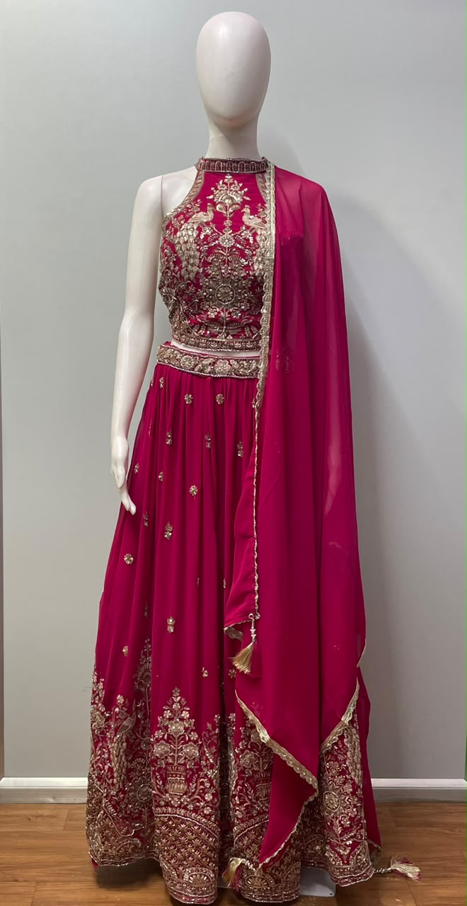 Close view of the gold peacock motif embroidery on the rani pink lehenga