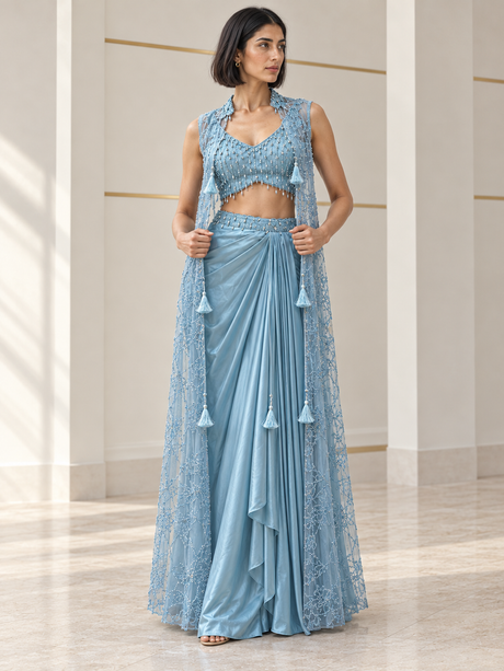 Powder blue skirt set with a pearl-detail blouse, draped skirt and sheer tassel cape