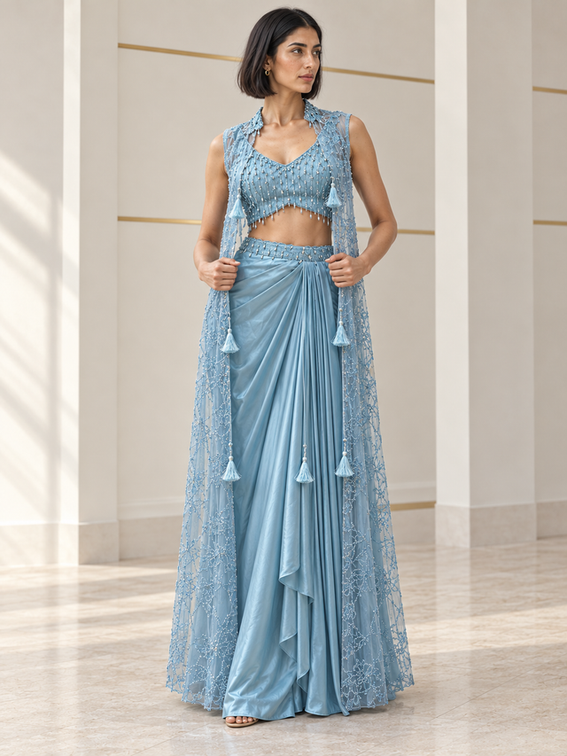 Powder blue skirt set with a pearl-detail blouse, draped skirt and sheer tassel cape