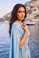 Full-length view of an ice blue pearl cape saree set on the model