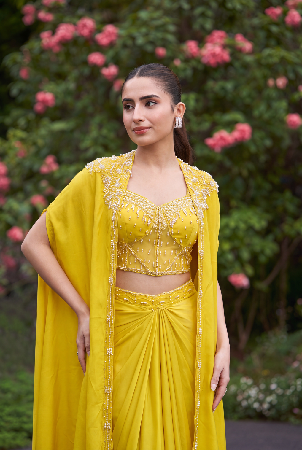 Full-length view of a lemon yellow pearl cape saree on the model