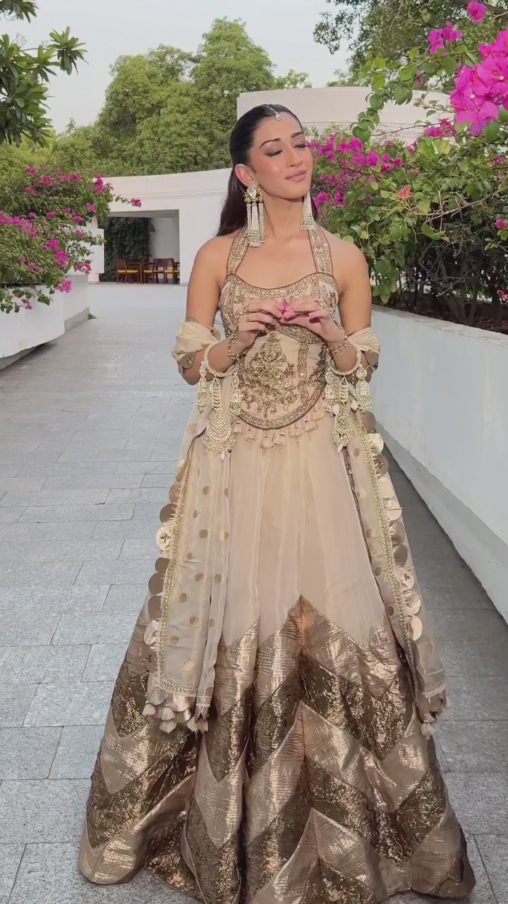 Ivory gold corset embroidered lehenga ensemble shown in movement on the model