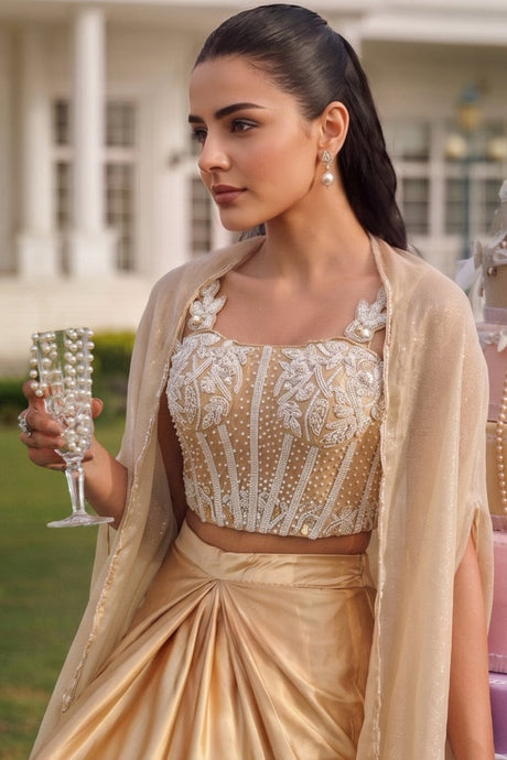 Champagne gold draped skirt set with a silver jewel corset blouse and sheer cape