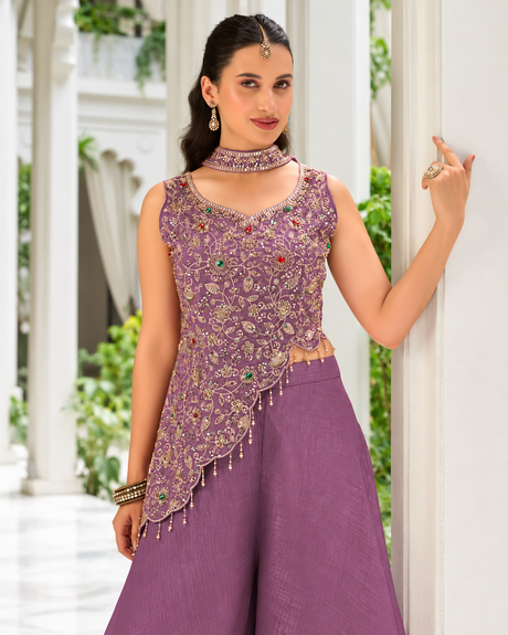 Emerald and ruby gemstone accents across the dusty mauve bodice